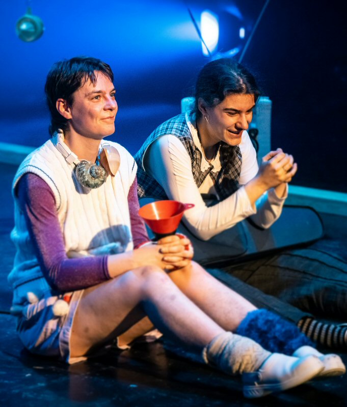 Flora Van Canneyt & Eva Mareen zitten op het podium, samen glimlachend